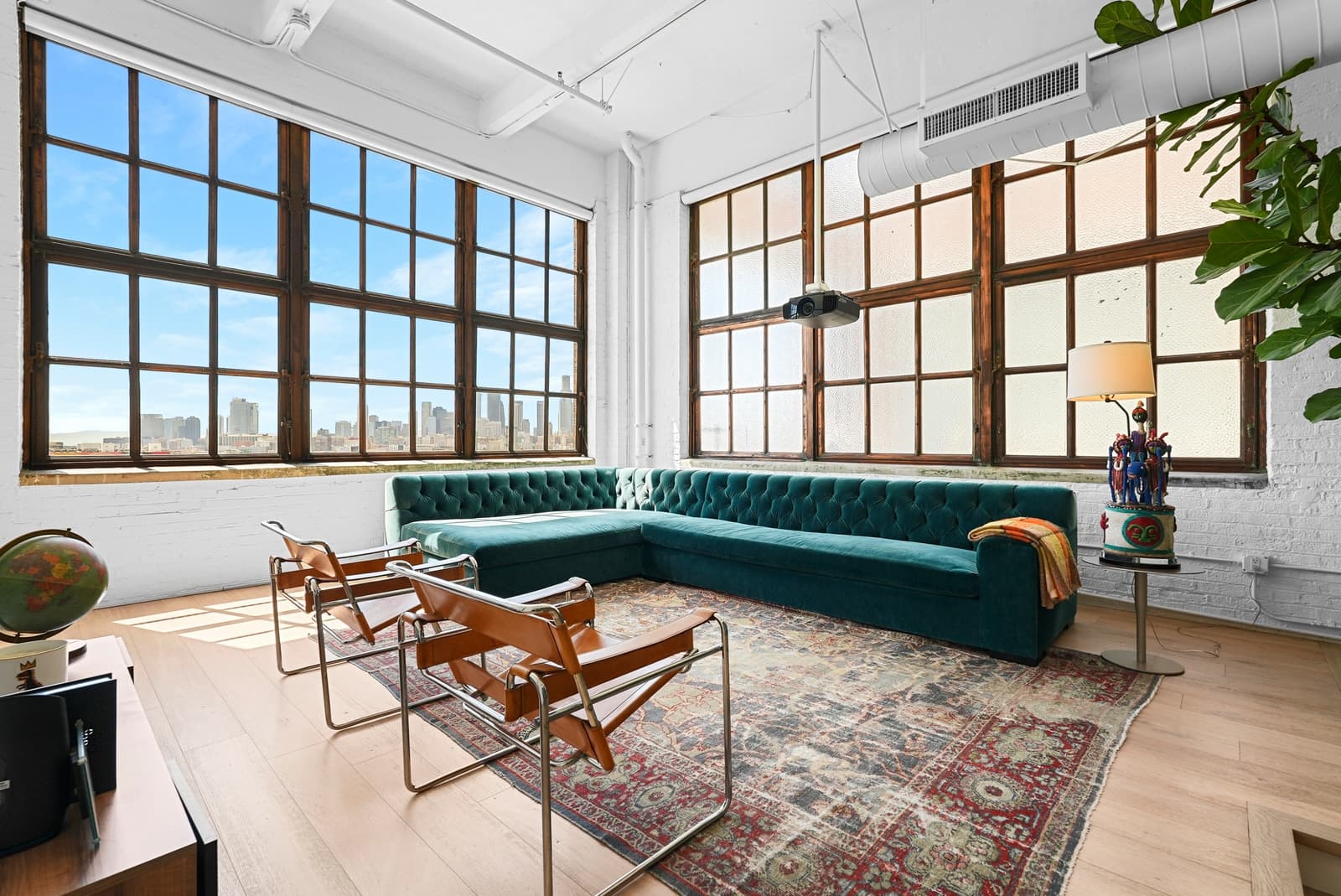 Arts District loft by day, green velvet sectional and leather sling chairs