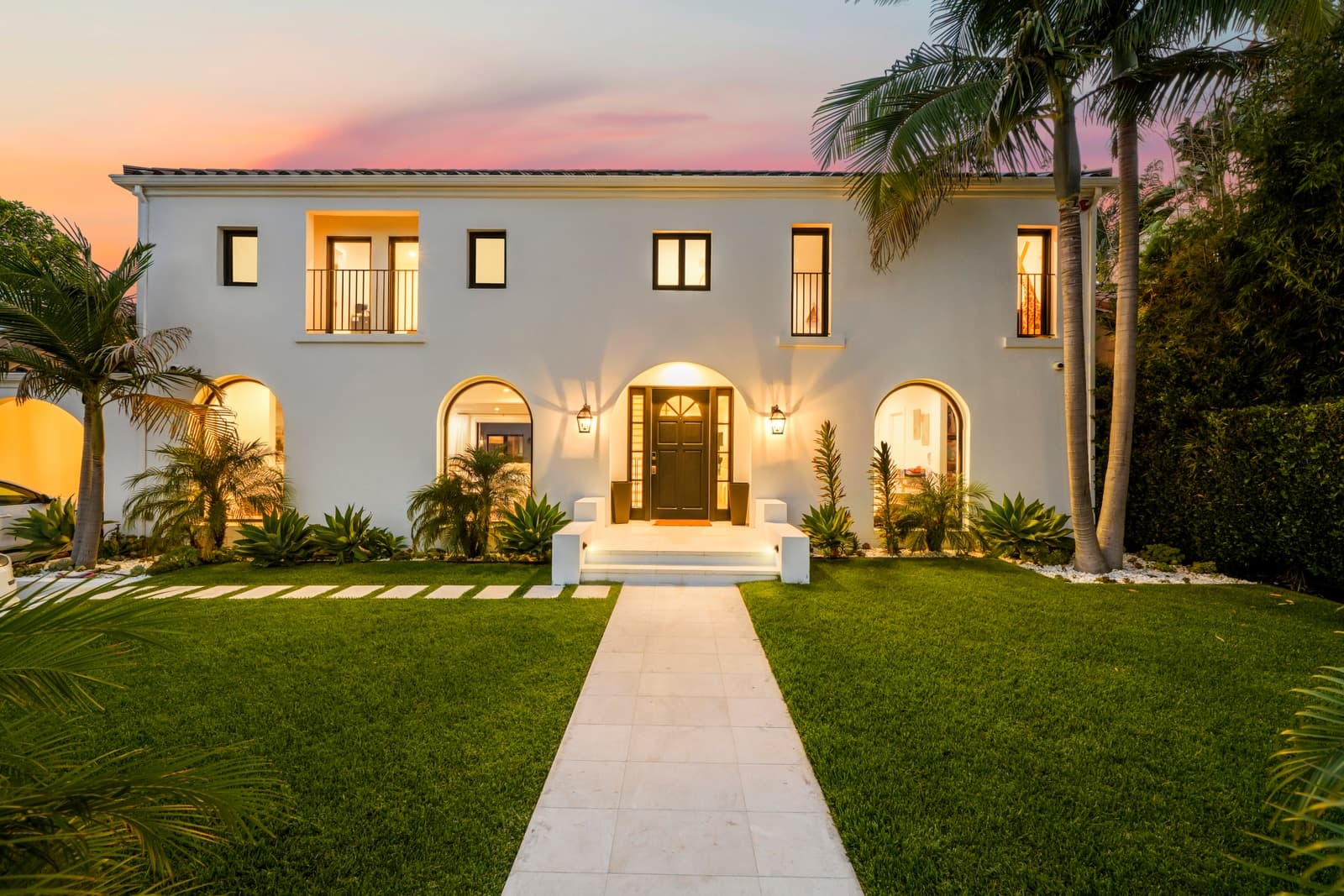 Beverly Hills Spanish modern at twilight, palms and lit arches