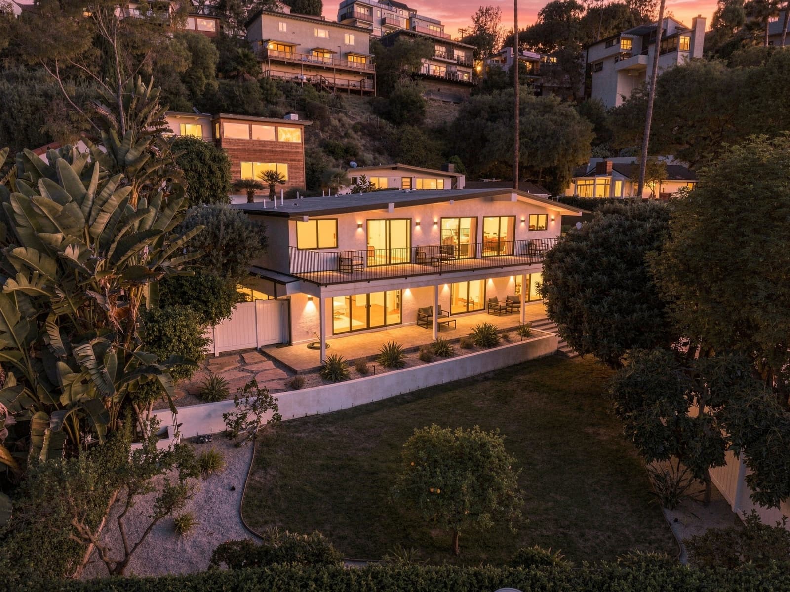 Hillside modern home from above at virtual twilight